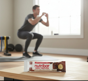 Nutribar high protein bar on a table with a person exercising in the background
