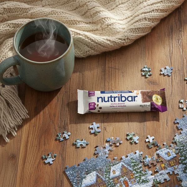 Nutribar on a wooden table with a mug of tea and a puzzle.